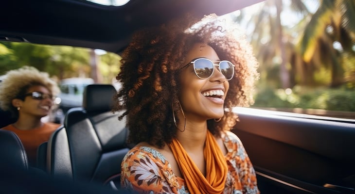 women in a car smiling