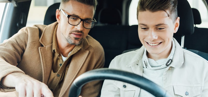 Father lecturing teen son inside car