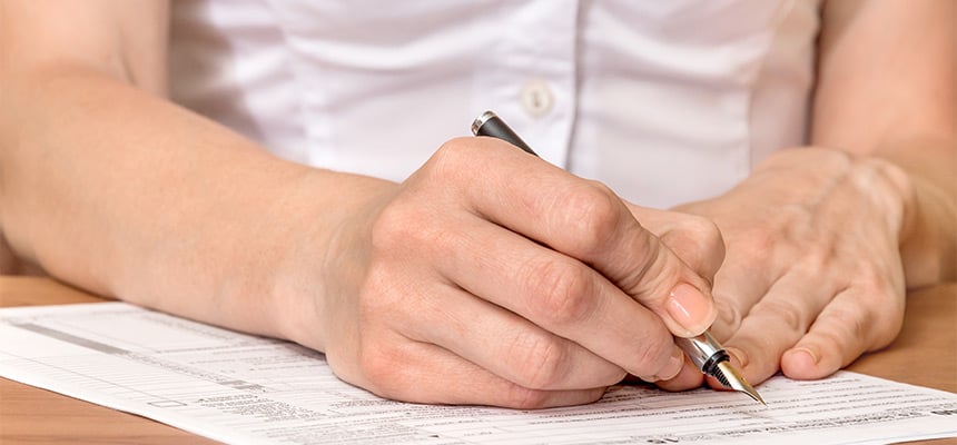 Closeup of hand signing documents