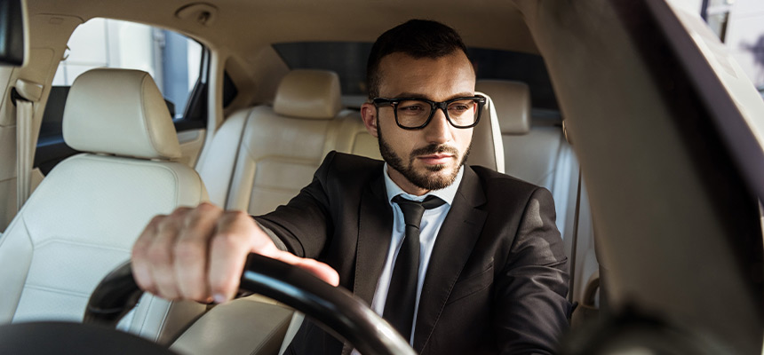 Man in business attire driving car