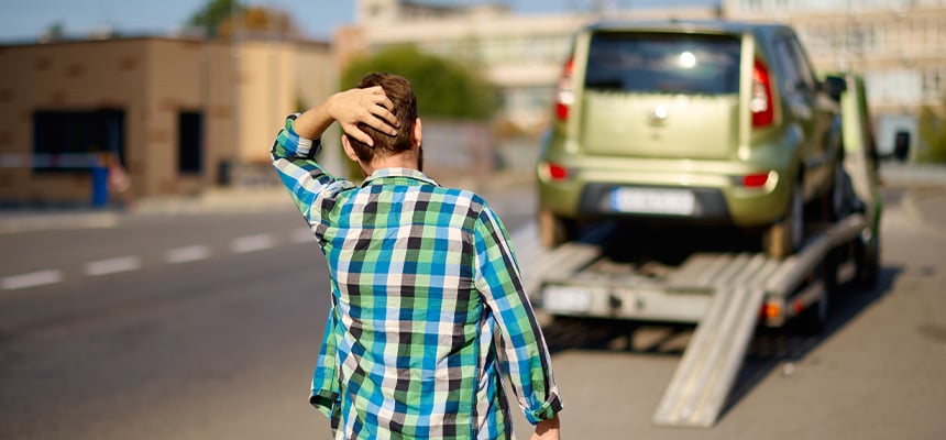 Worried man looking from afar at their towed car