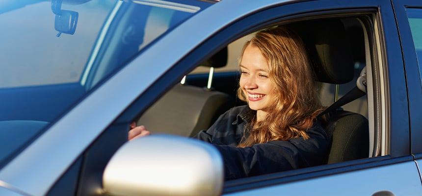 Teenage girl smiling inside car