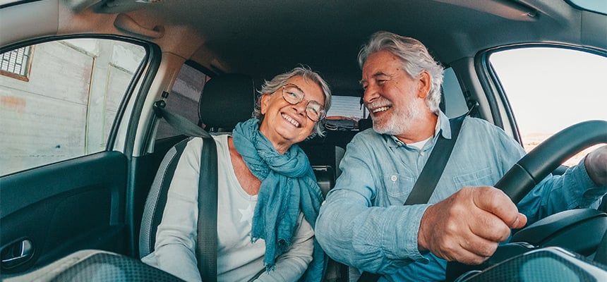 Smiling senior couple driving car