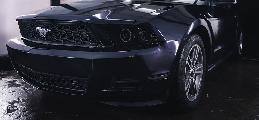 Closeup of the front of a dark navy Ford Mustang