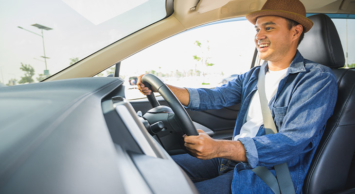 Man with hat driving car