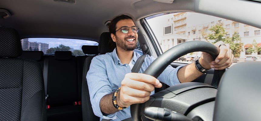 Smiling man with glasses driving car