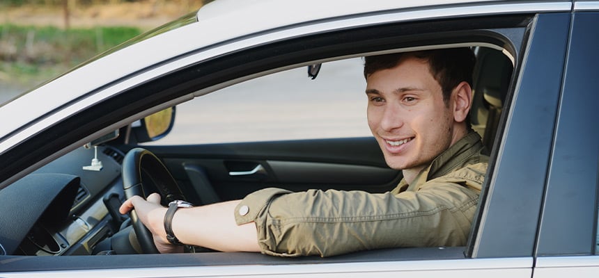 Young white man driving car