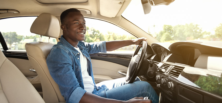 Side view of smiling man driving car