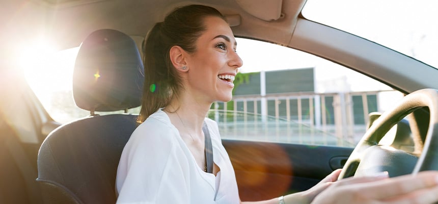 Young woman smiling and driving