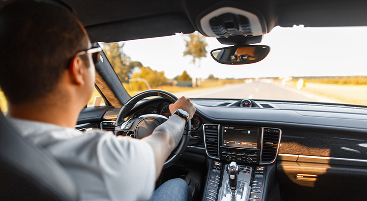 Back shot of man with sunglasses driving car