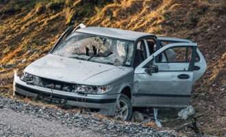 Car totaled on the side of the road