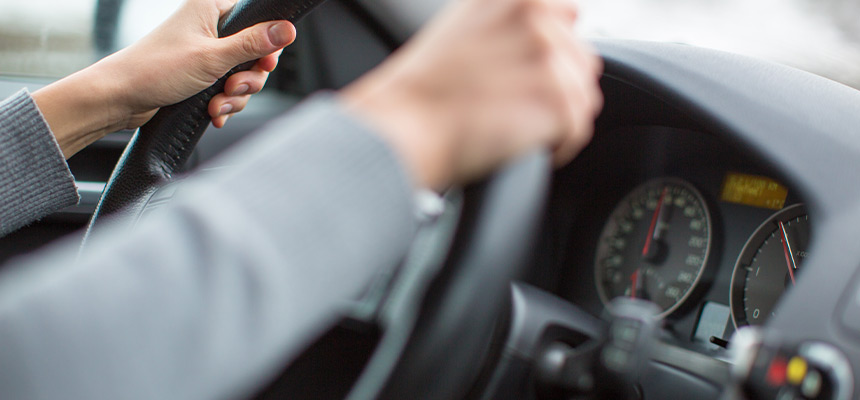 Hands gripping steering wheel