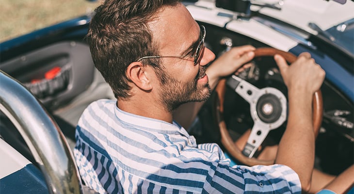 Man with sunglasses driving convertible