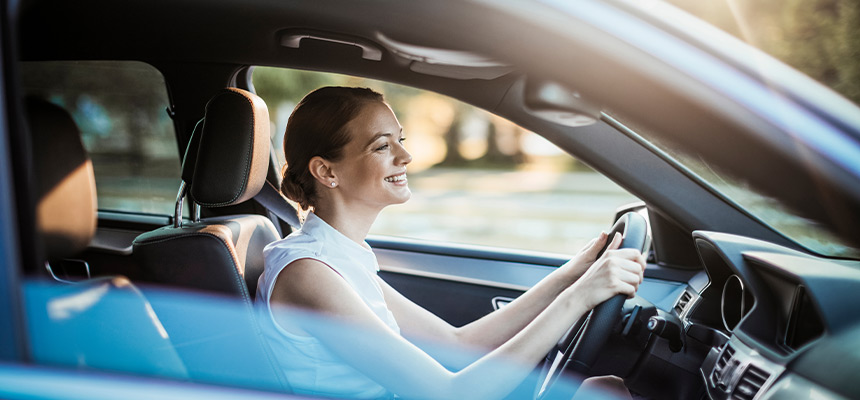 Young woman smiling and driving