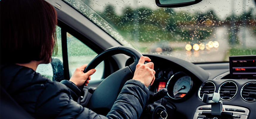 Backside of woman driving car during rain