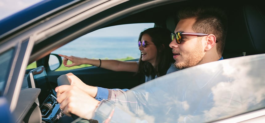 Couple wearing sunglasses while driving