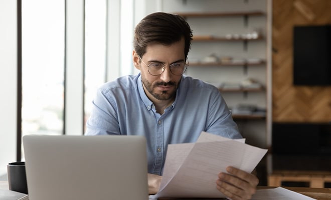 Serious man with glasses looking at paperwork