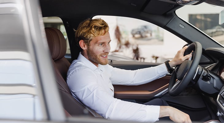 Man with blonde hair driving car