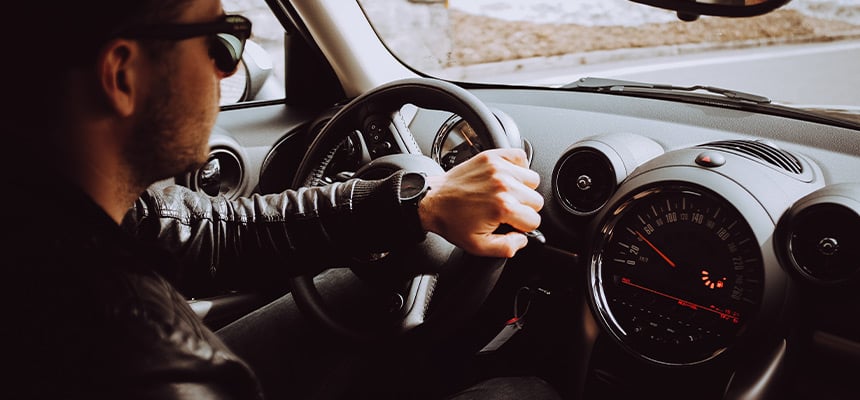 Man wearing leather jacket driving car