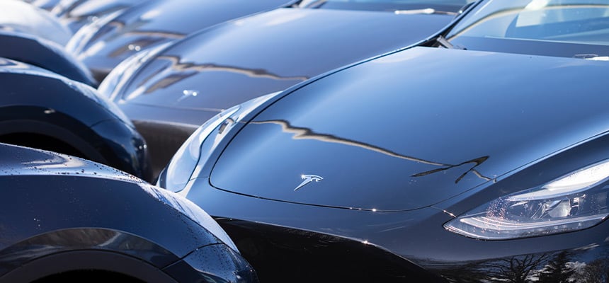 Multiple grey Tesla Model Y cars parked next to each other