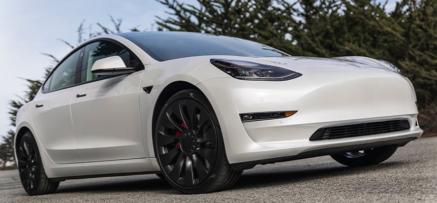 A low angle photograph of a parked white Tesla Model Y