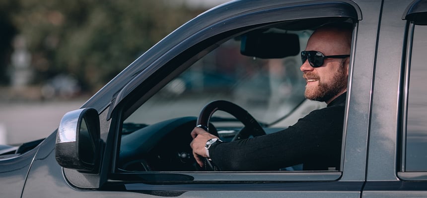 man with sunglasses driving a car