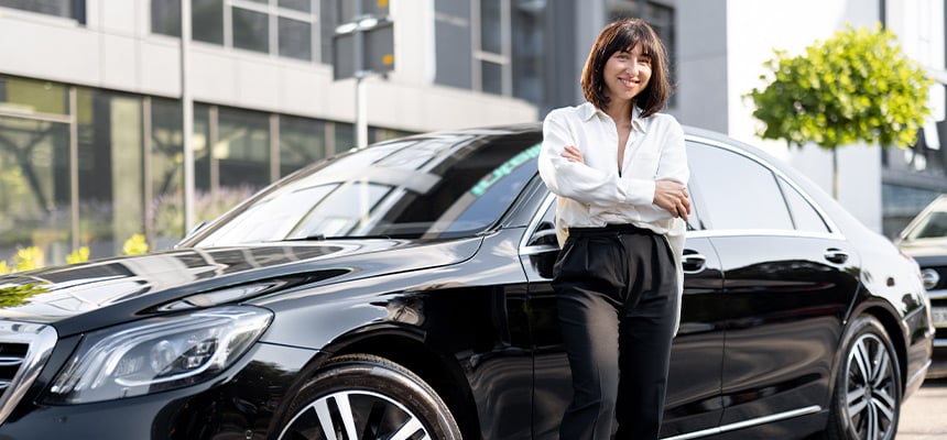 woman standing beside a car smiling